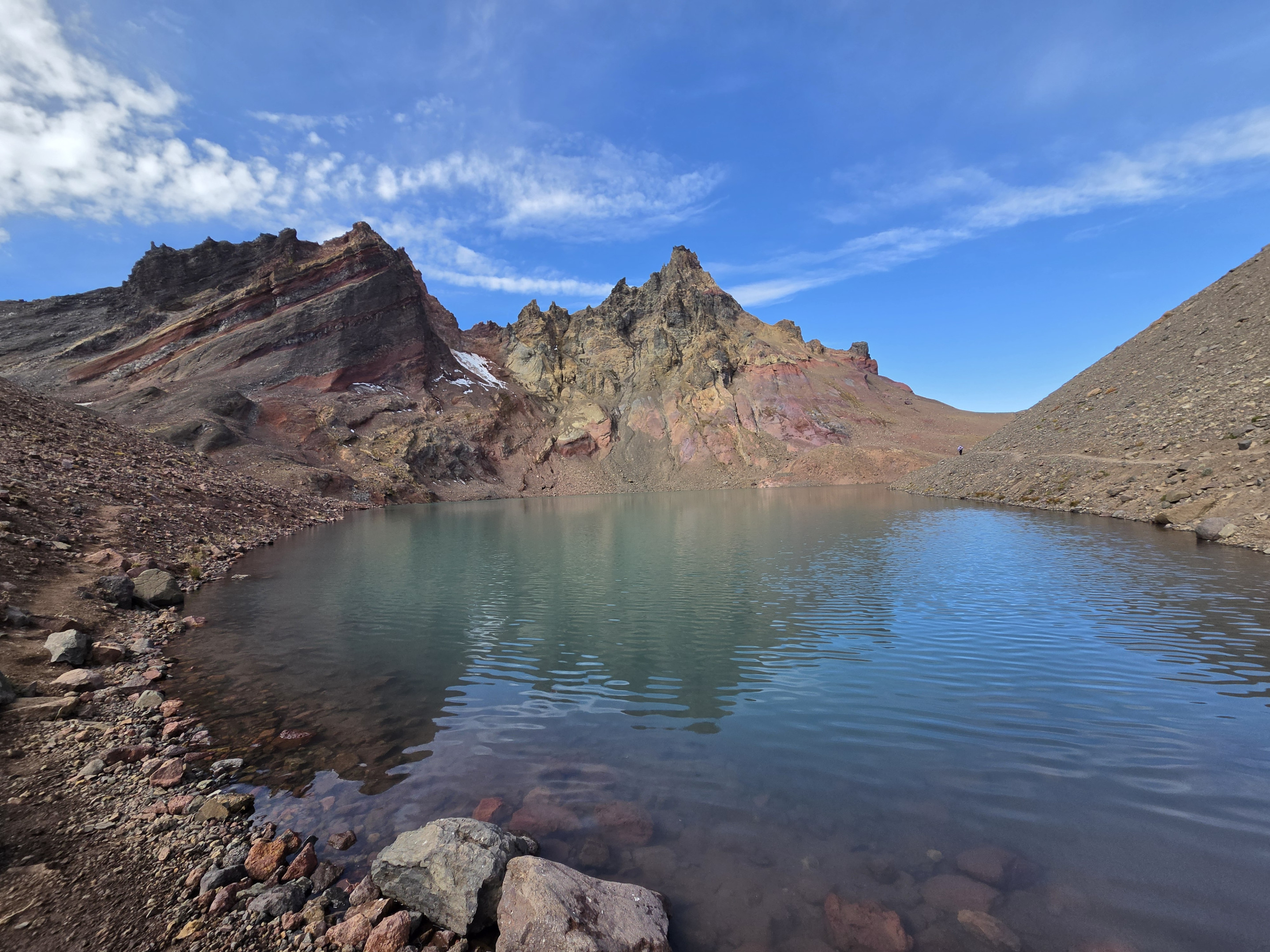 The blue-green water of No Name Lake beneath the rugged cliffs of Broken Top.